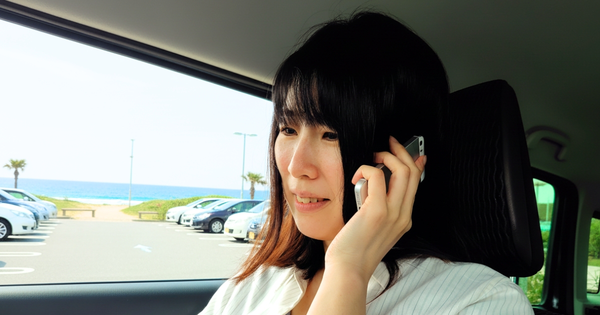  坐骨神経痛のつらい症状を改善するため、笑顔鍼灸院にスマホでネット予約する女性のお客様