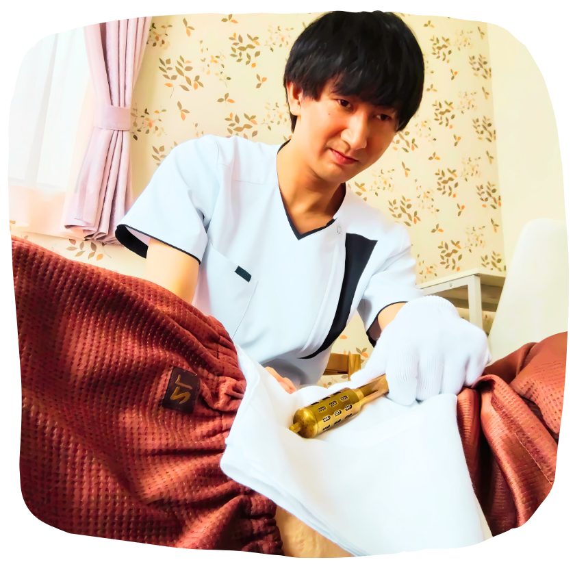 温灸棒ローラーで腰から背中を温めている施術の様子